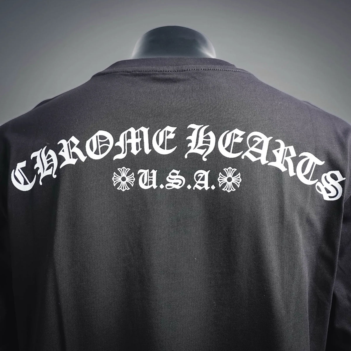 Back of dark long-sleeve T-shirt with large white U.S.A. text and ornamental emblem
