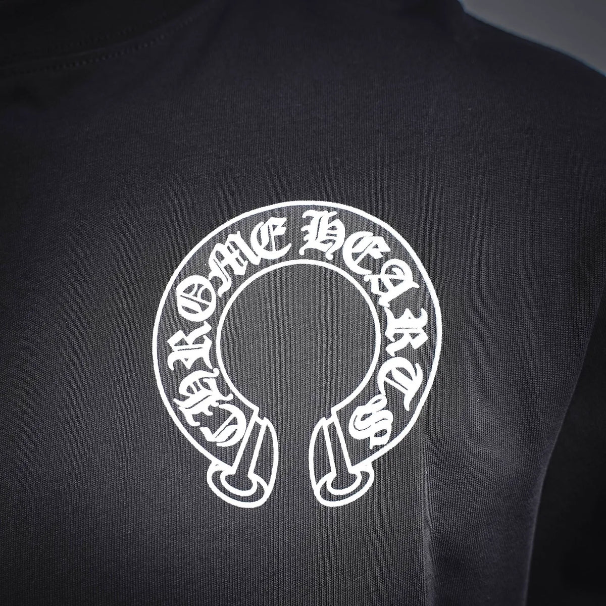 Dark long-sleeve T-shirt front with white circular logo emblem