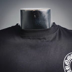 Dark long-sleeve T-shirt neckline and small white chest emblem