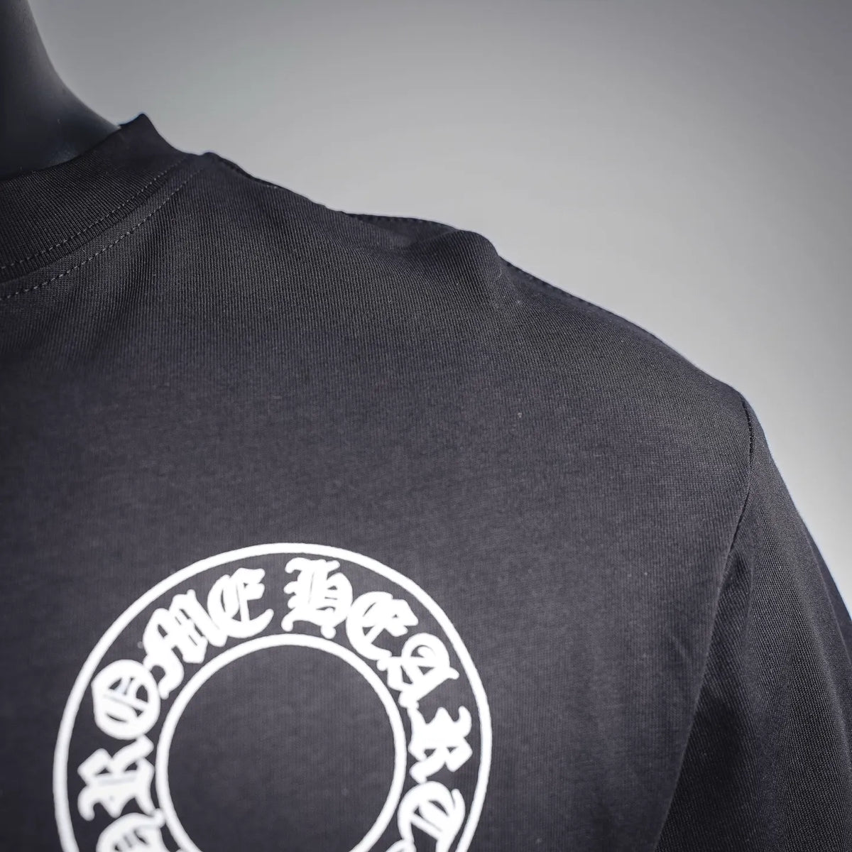 Dark long-sleeve T-shirt shoulder with white circular logo