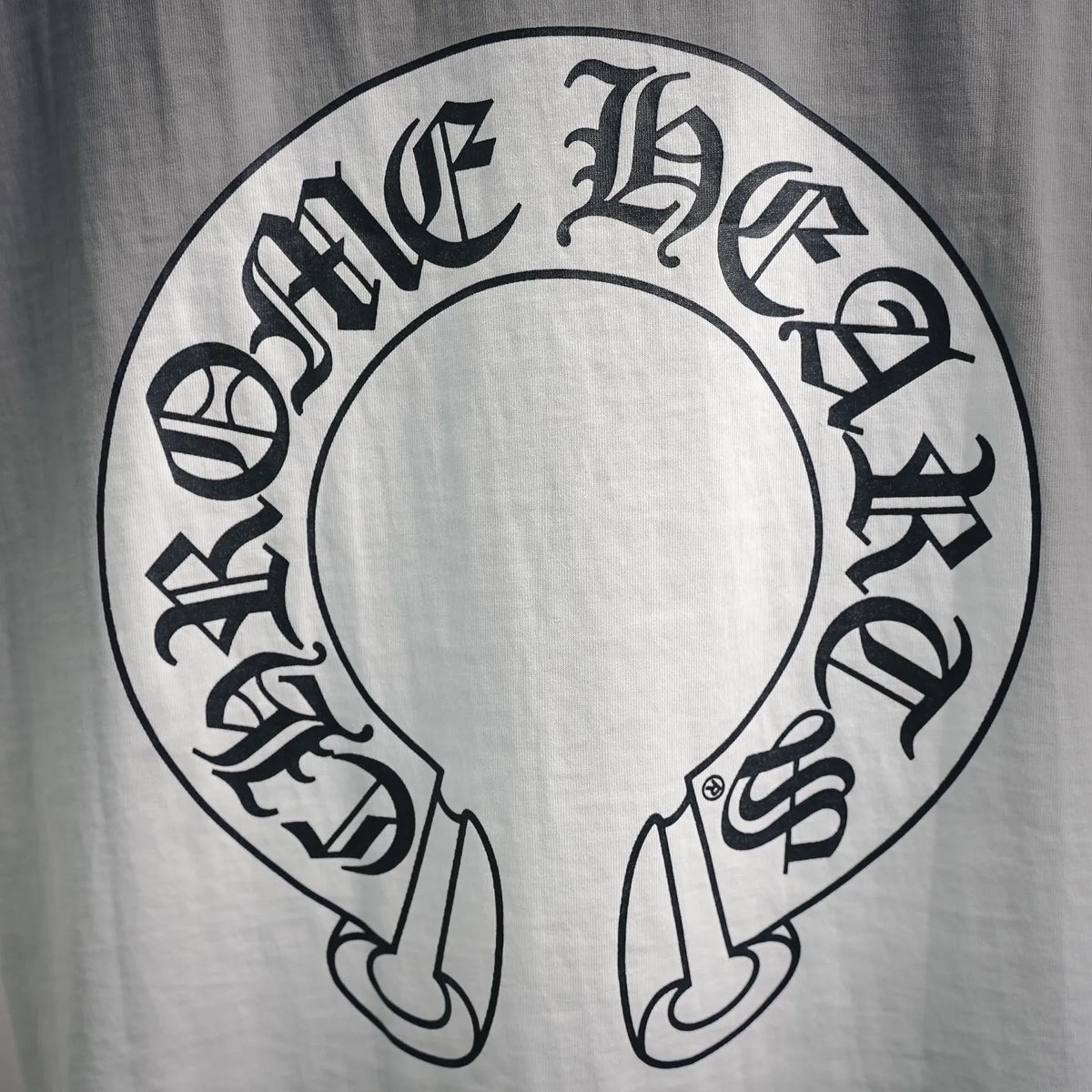 Close-up of circular Chrome Hearts graphic on the back of a white T-shirt