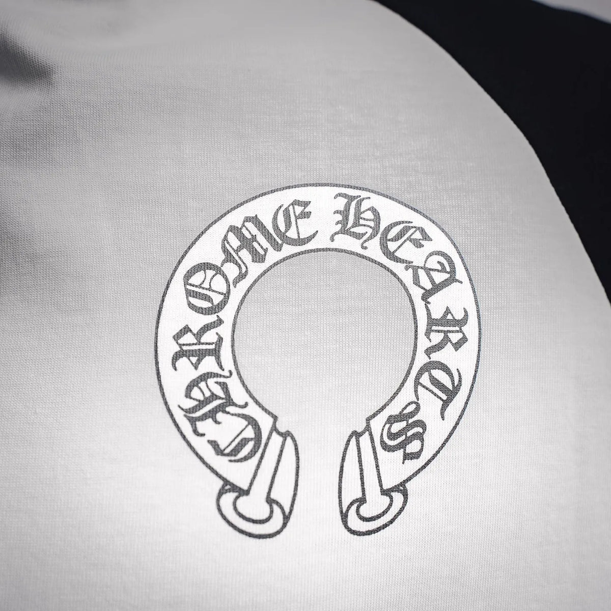 Close-up of circular Chrome Hearts logo graphic on the front of a white T-shirt