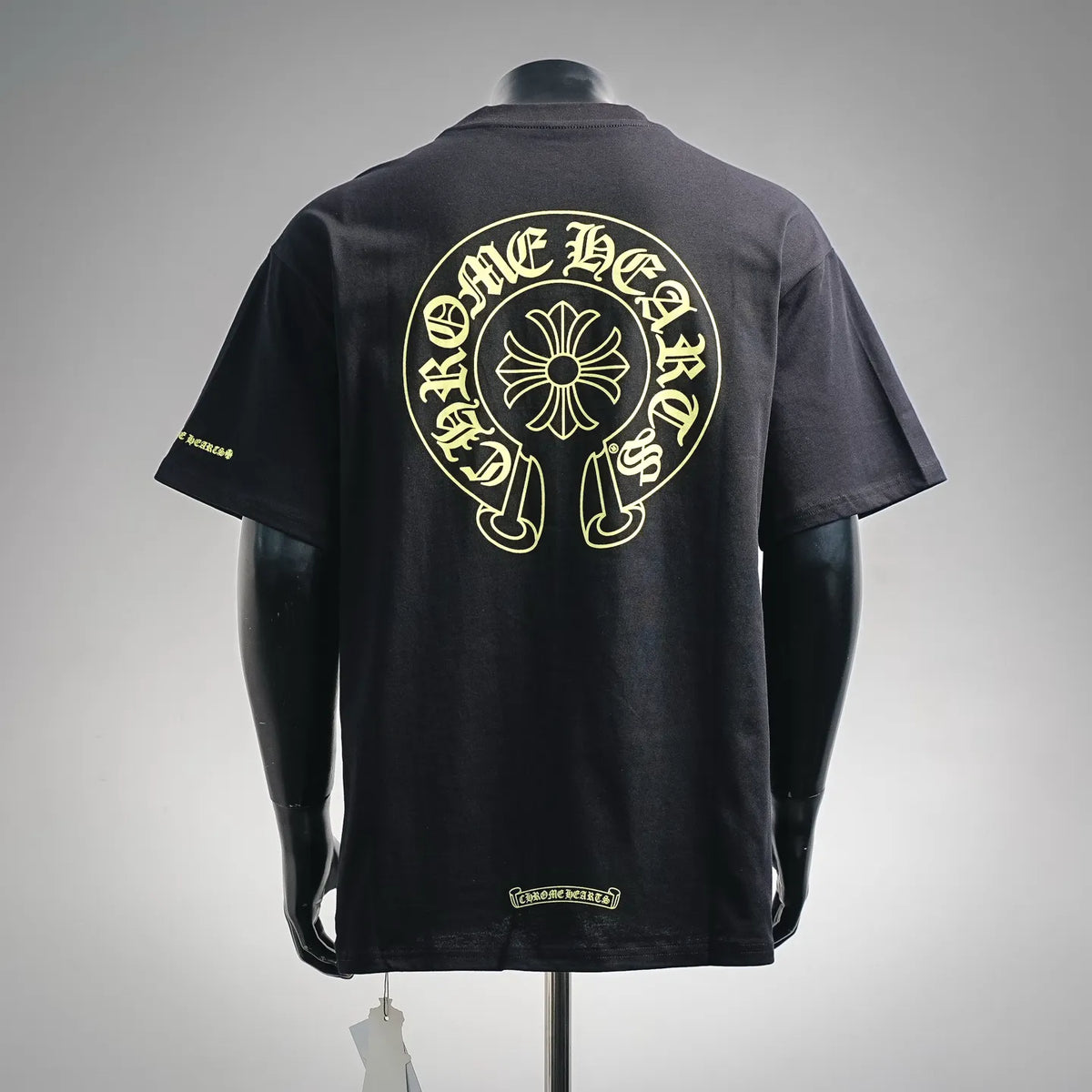 Black crew-neck T-shirt with large back circular gold graphic and small yellow sleeve mark