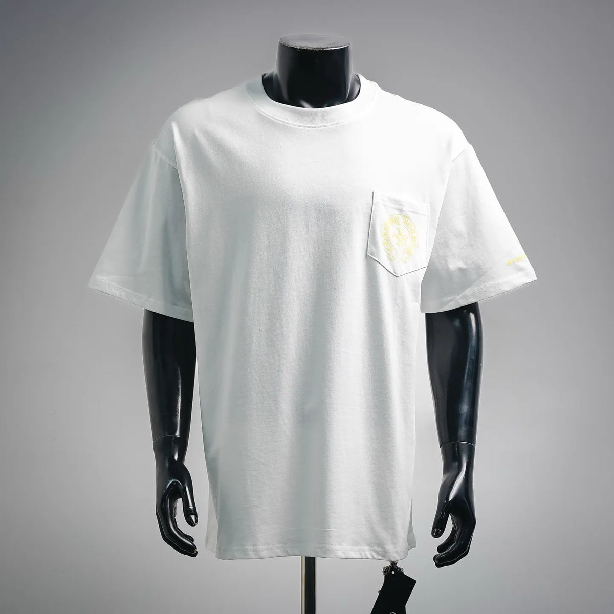 White short-sleeve T-shirt with small yellow chest logo print on left pocket area