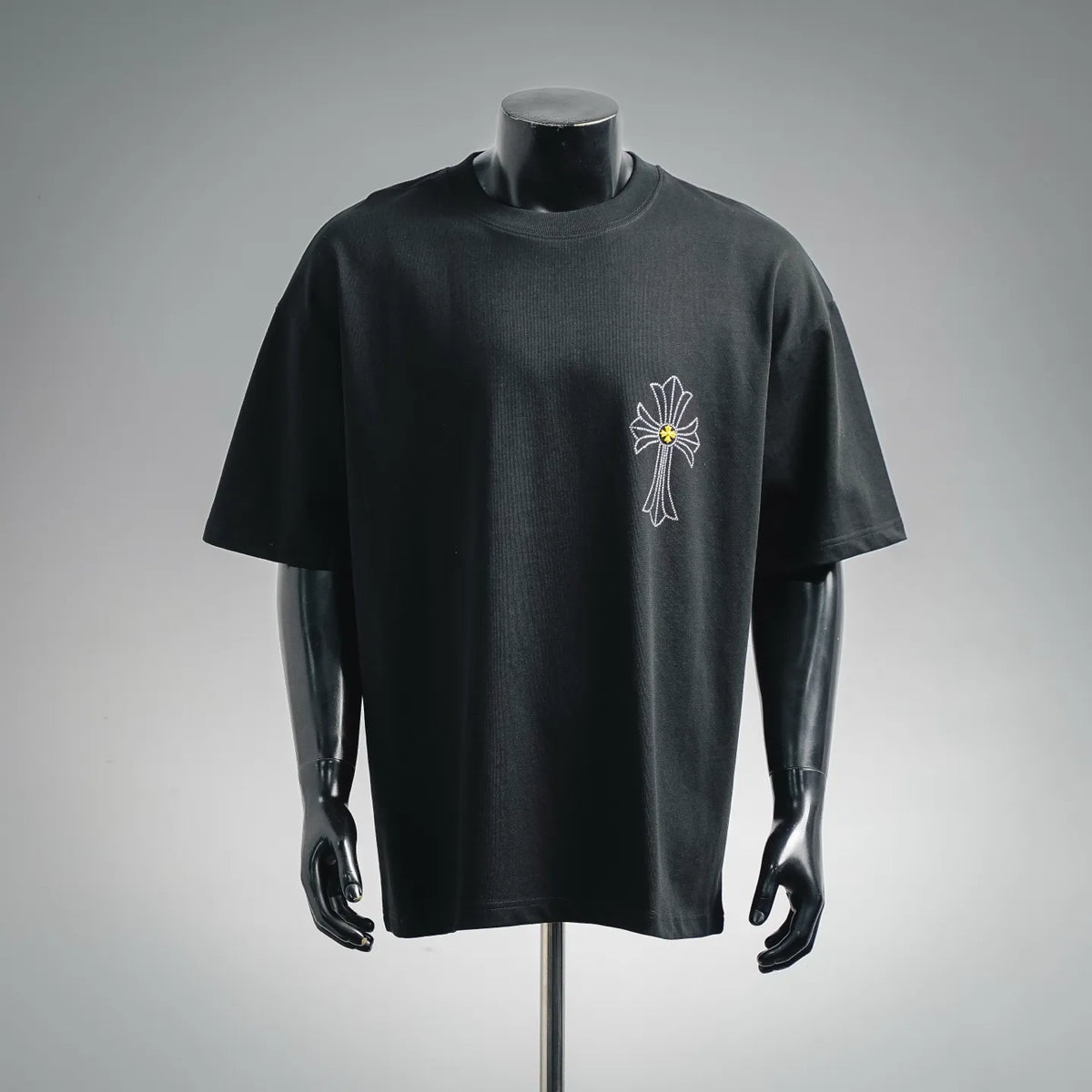 Black short-sleeve T-shirt with small rhinestone cross graphic with yellow center