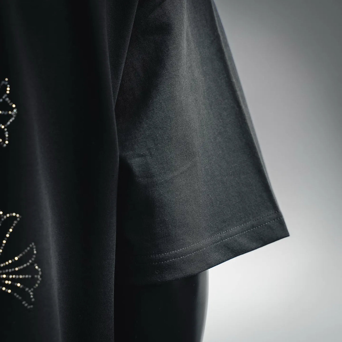 Black short-sleeve T-shirt side view with clean stitched hem