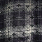 Close-up of dark plaid shirt with floral line pattern across the front