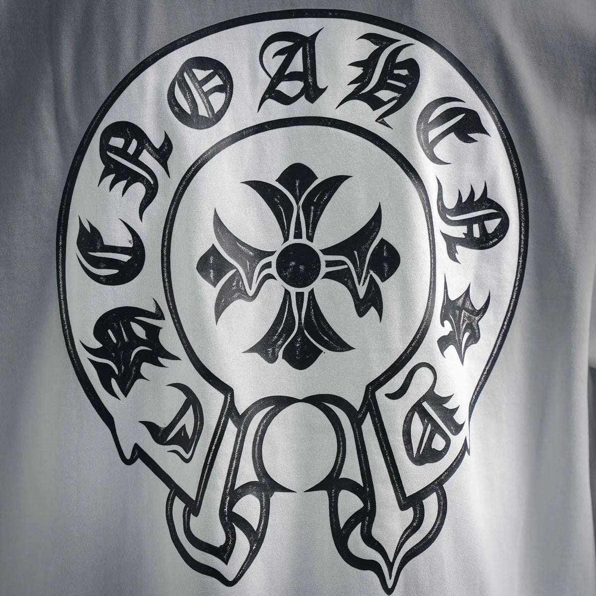 Close-up of T-shirt back skull emblem graphic in black and gray