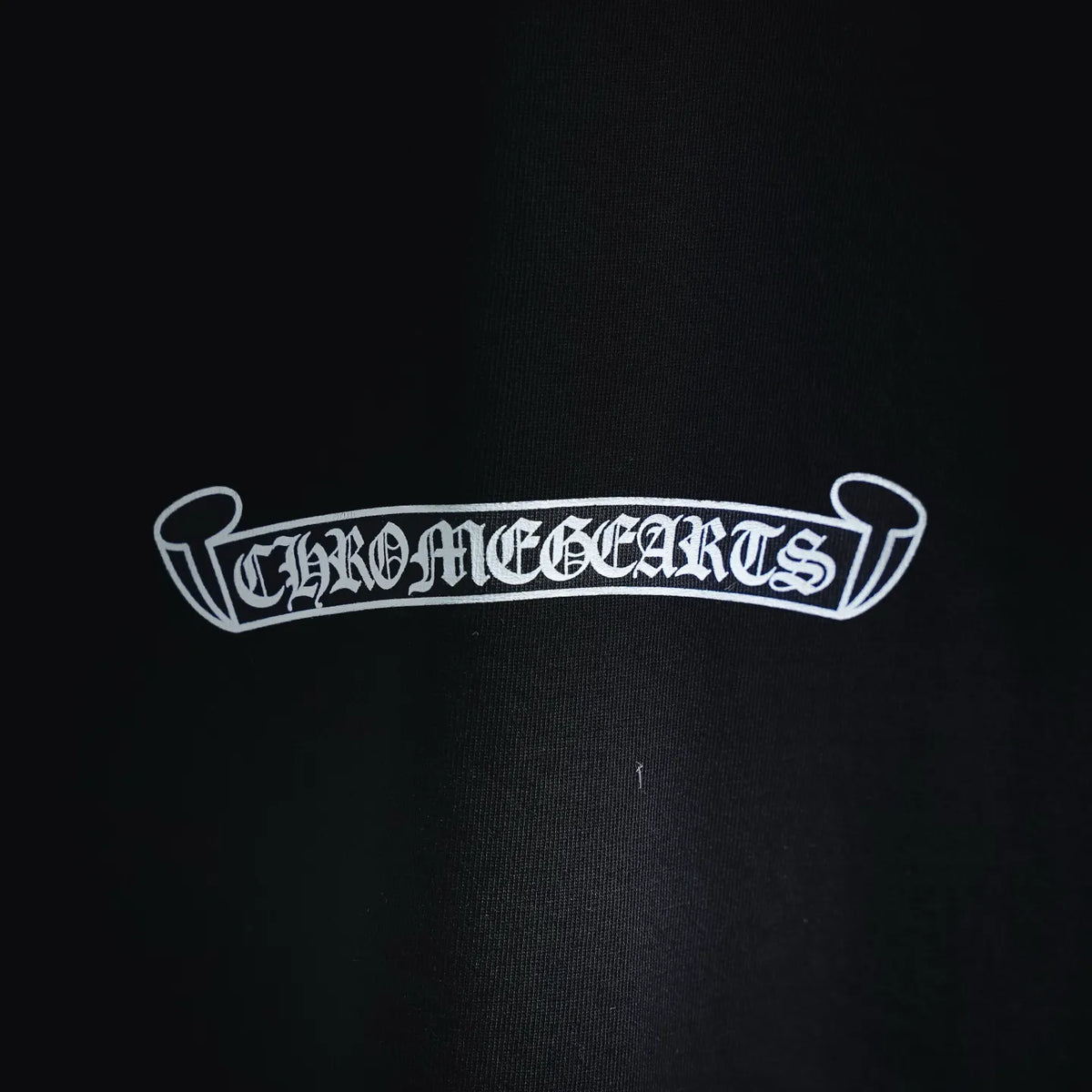 Black T-shirt chest logo patch with ornate white lettering