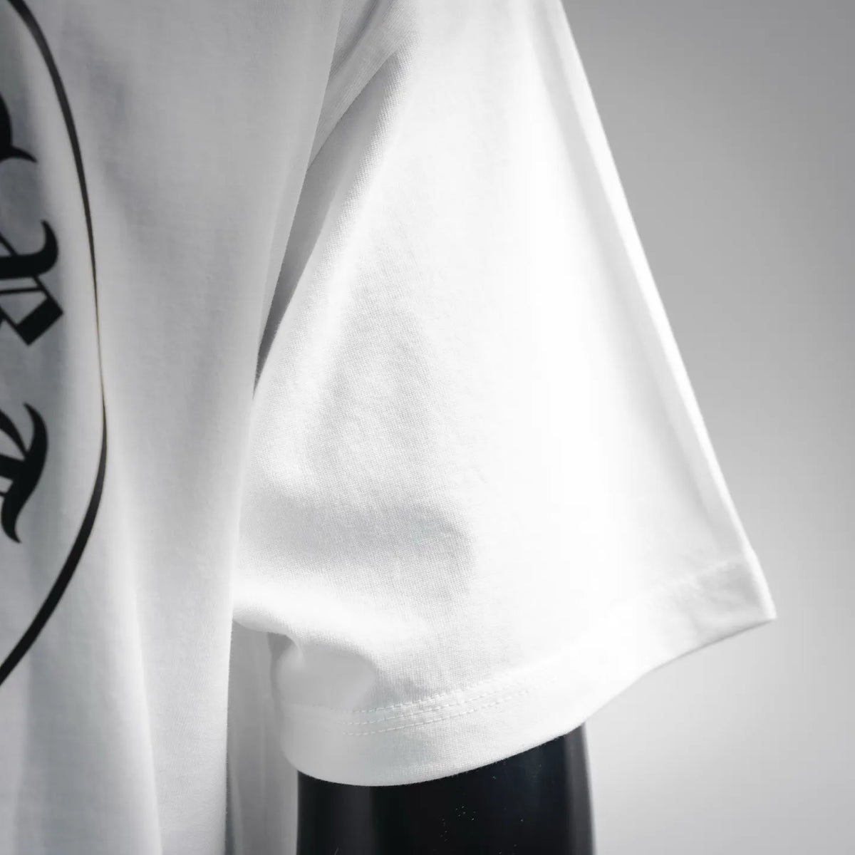 White T-shirt side and sleeve hem close-up with smooth fabric drape