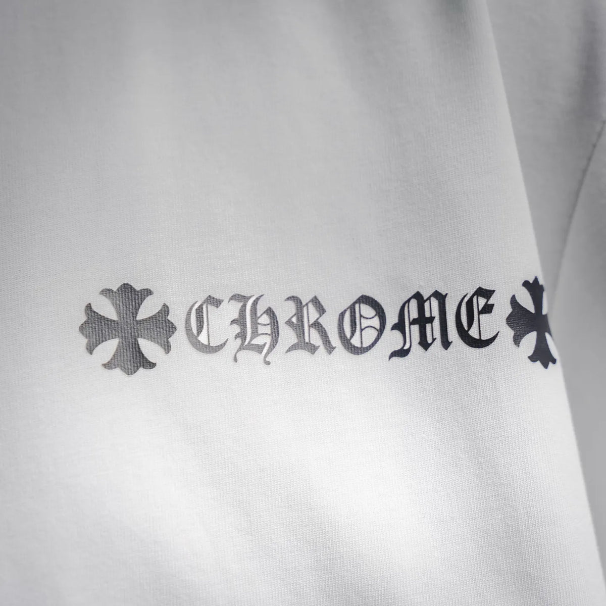 White T-shirt with large dark “CHROME HEARTS” logo print