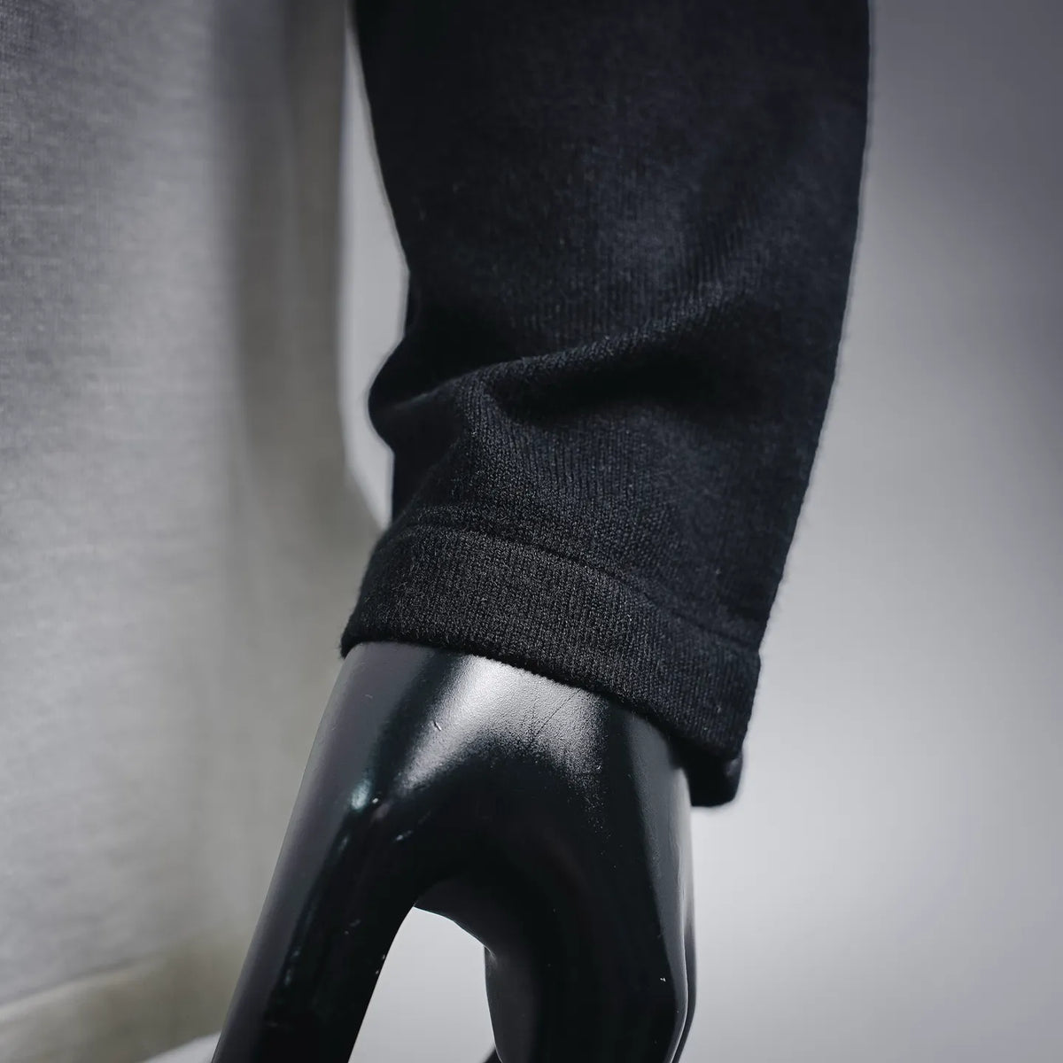 Close-up of black ribbed sleeve cuff on a white-and-black long-sleeve raglan T-shirt