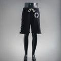 Black drawstring shorts with elastic waistband and circular front logo patch