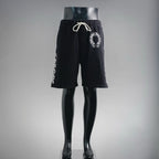 Black drawstring shorts with elastic waistband and circular front logo patch