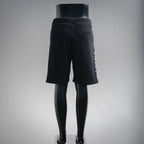 Black drawstring shorts viewed from side with vertical graphic text on leg