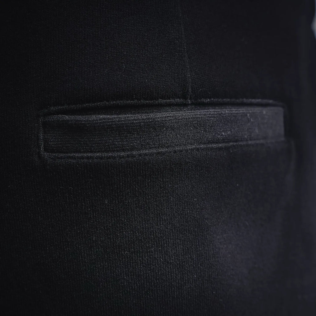 Black shorts fabric close-up showing stitched pocket opening and seam details