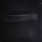 Black shorts fabric close-up showing stitched pocket opening and seam details