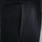 Black shorts close-up showing outer leg seam and relaxed fabric panel