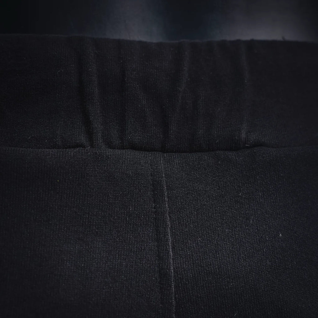 Black shorts waistband close-up with center seam and stitched elastic band