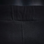 Black shorts waistband close-up with center seam and stitched elastic band