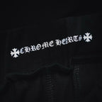 Black shorts fabric close-up with white 'Chrome Hearts' style text graphic