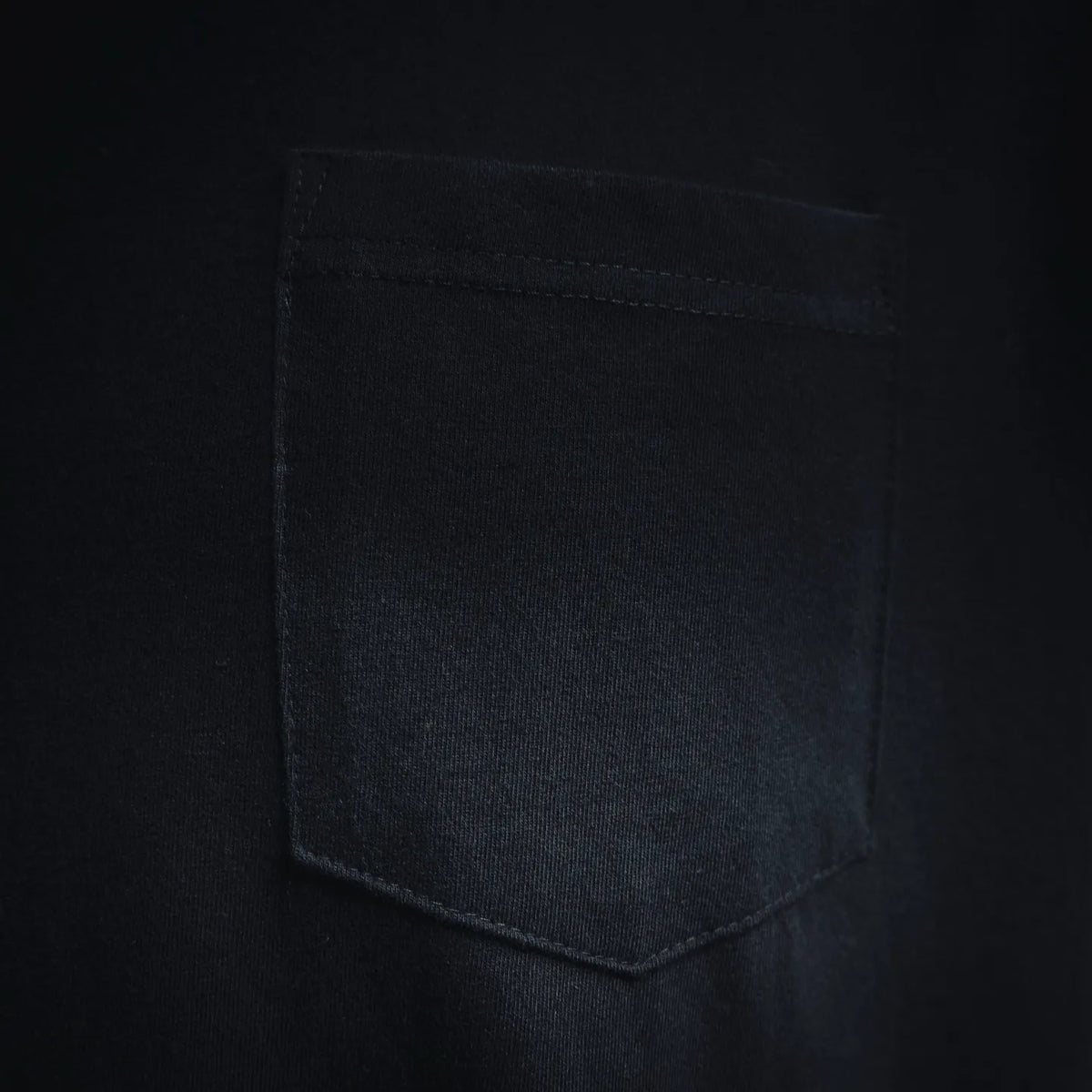 Close-up of T-shirt chest pocket on dark fabric