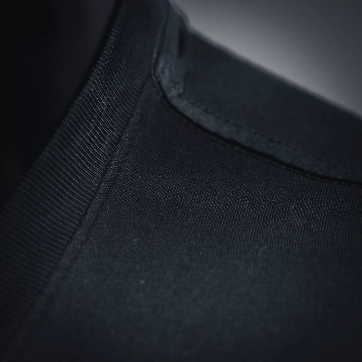 Close-up of dark crew-neck collar rib and shoulder seam