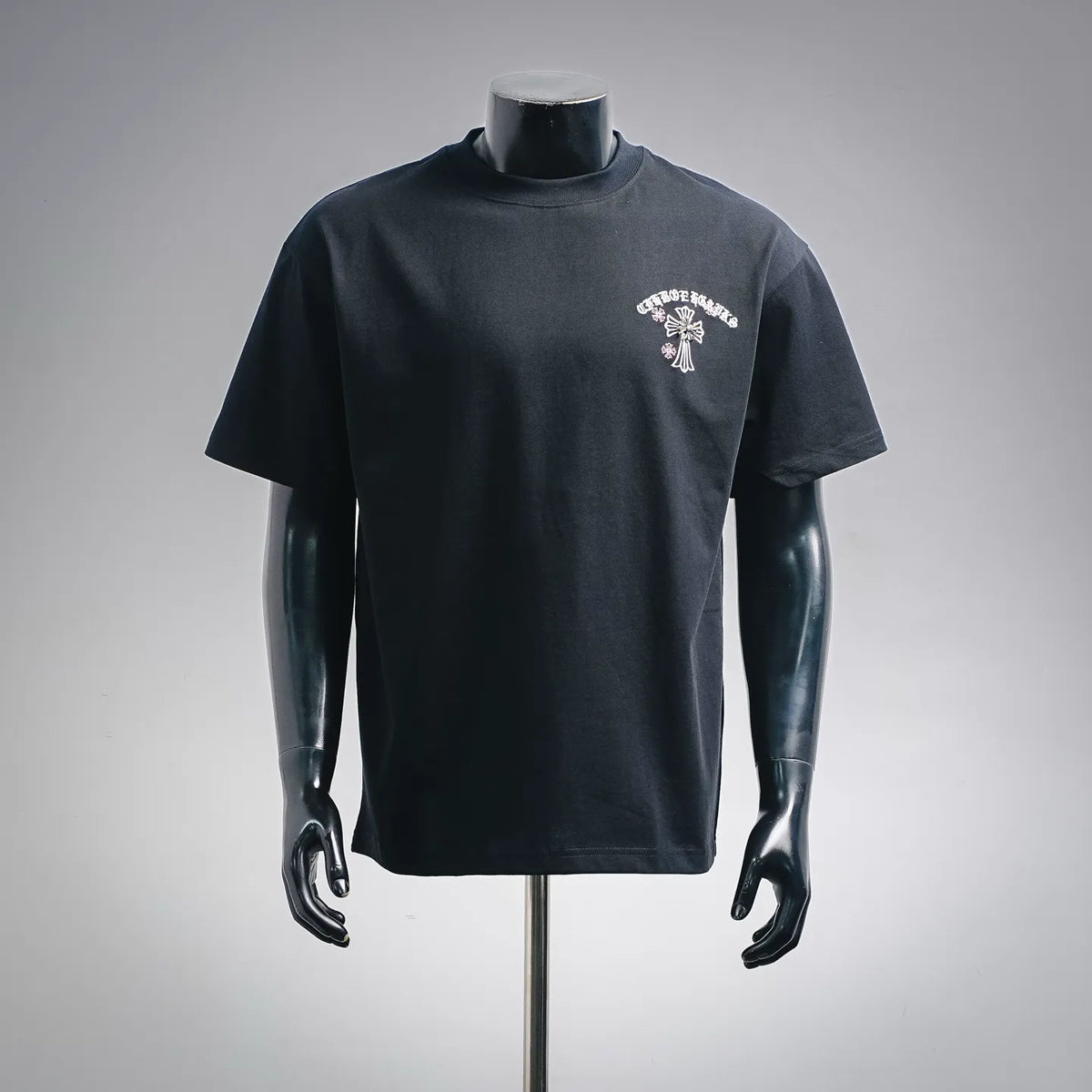Dark short-sleeve T-shirt with white and pink chest graphic on left.