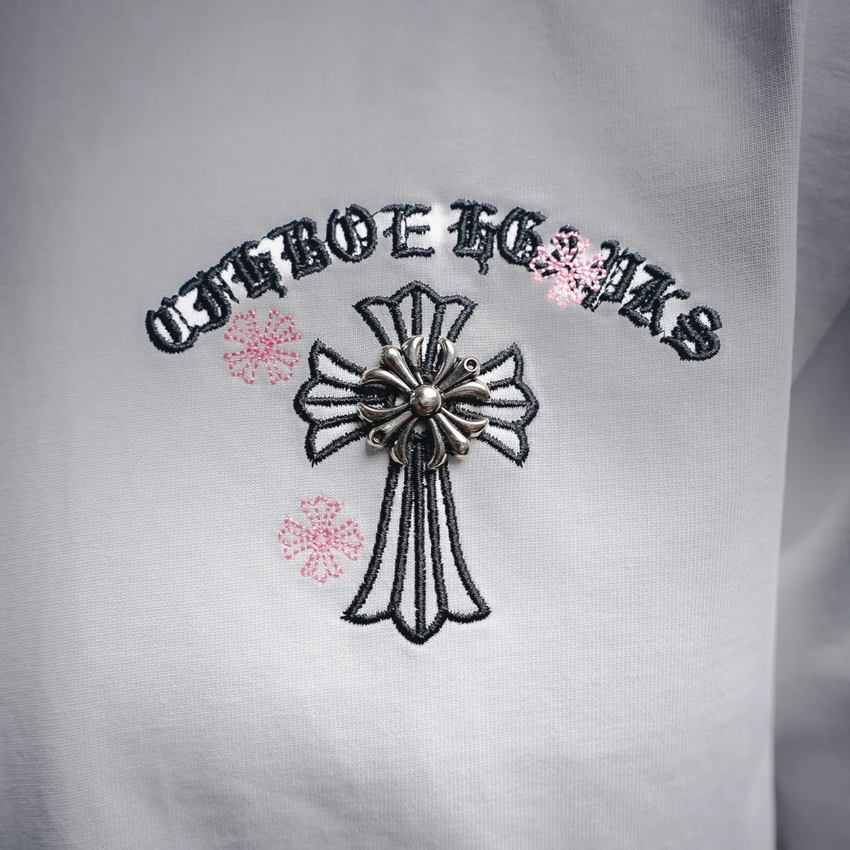 White short-sleeve T-shirt front graphic with cross and pink accents
