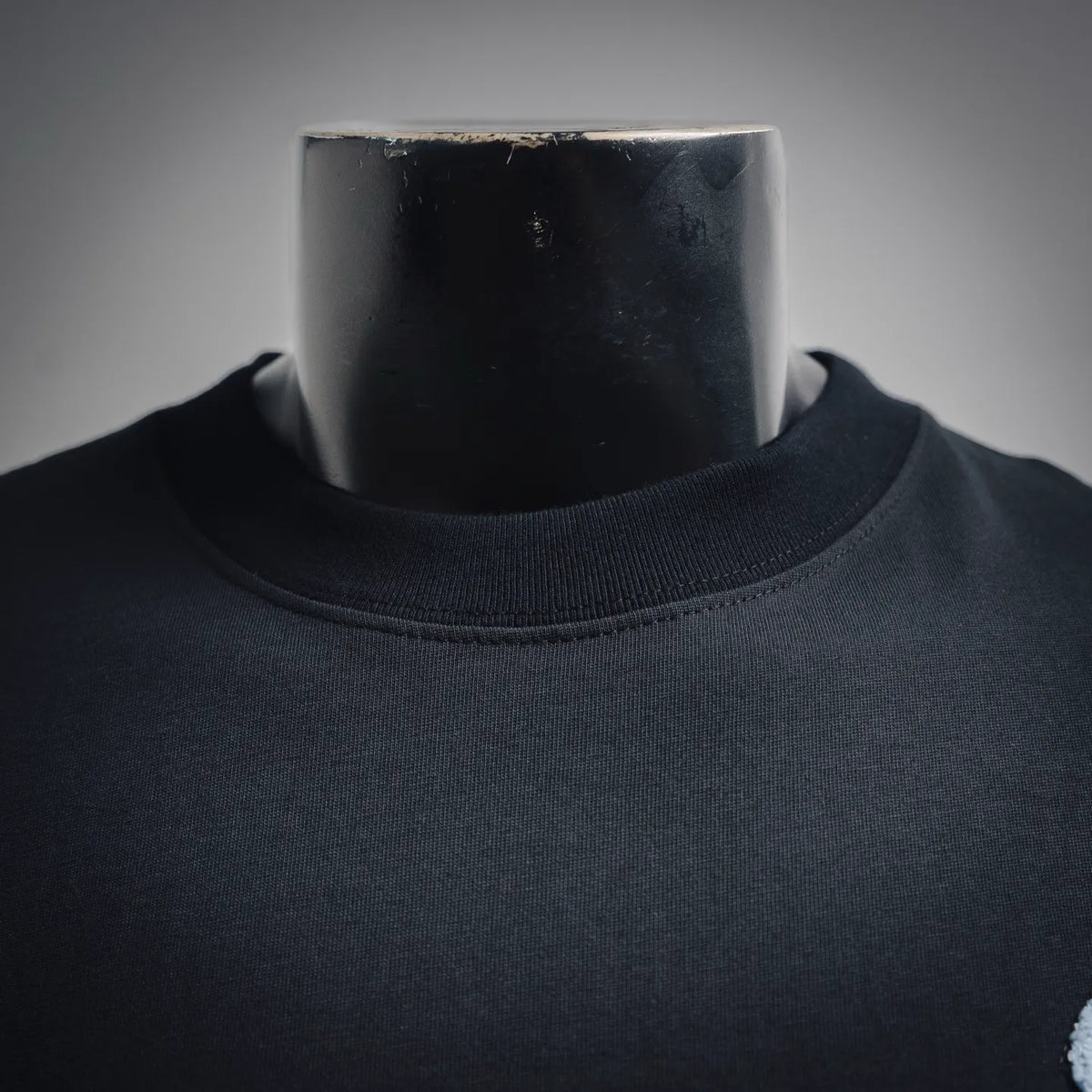 Dark crew-neck T-shirt close-up of neckline and smooth fabric texture