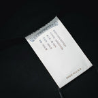 Black long-sleeve T-shirt label showing cotton content and "Made in U.S.A"