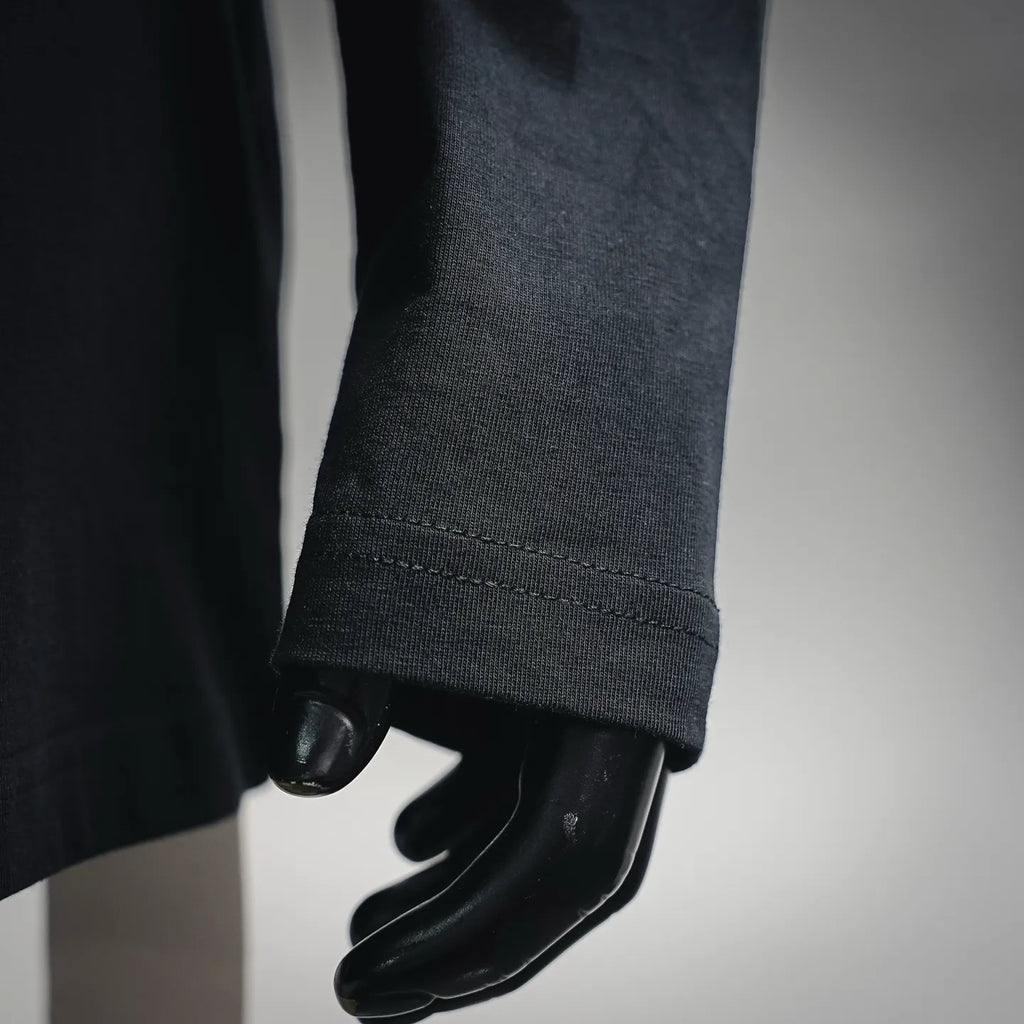 Black long-sleeve T-shirt sleeve cuff close-up with stitched hem