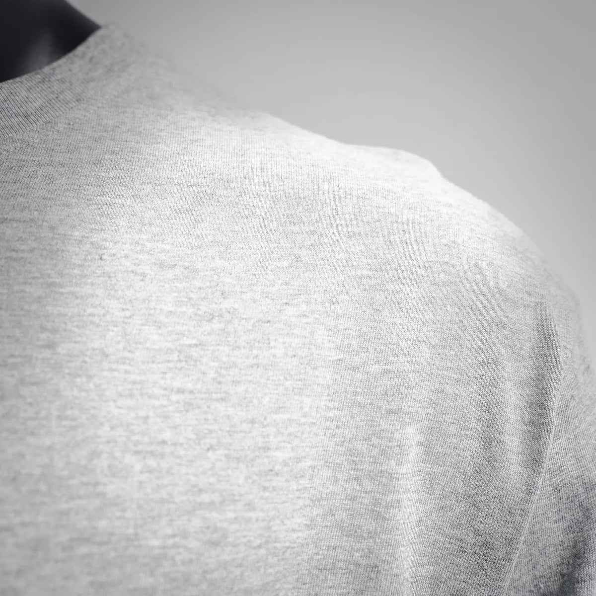 Heather gray long-sleeve T-shirt fabric close-up, crewneck shoulder area