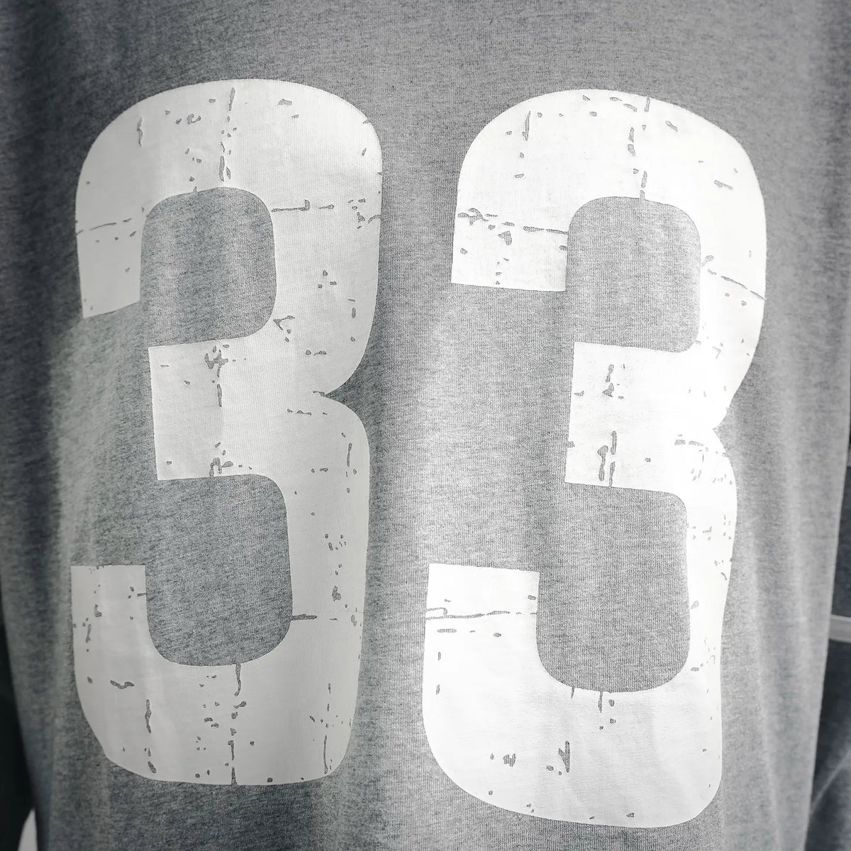 Close-up of large white "33" front graphic print on heather gray T-shirt