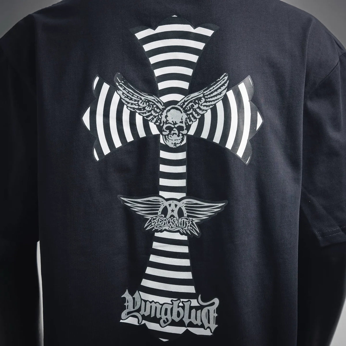 Dark navy T-shirt back close-up of cross graphic with striped ribbon and wings