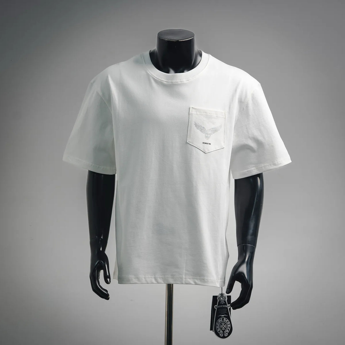 White short-sleeve T-shirt with front chest pocket and small graphic patch