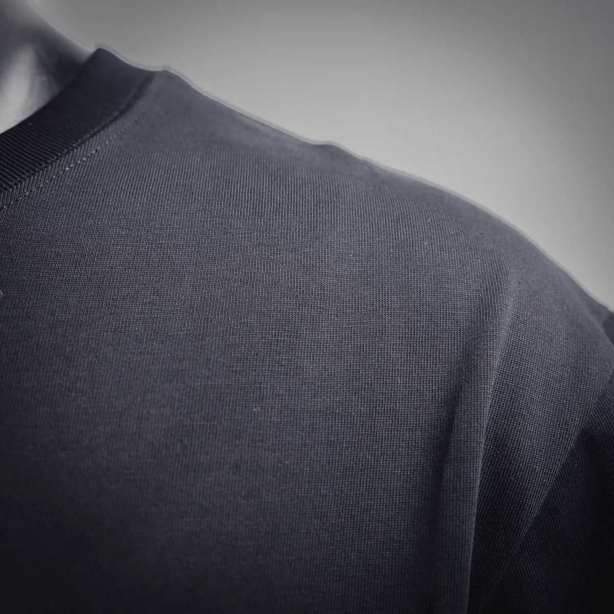Black short-sleeve T-shirt knit fabric close-up with subtle texture