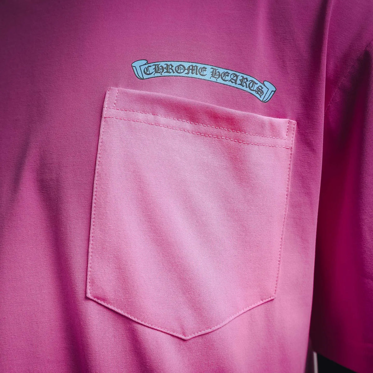Pink chest pocket on short-sleeve T-shirt with small logo above