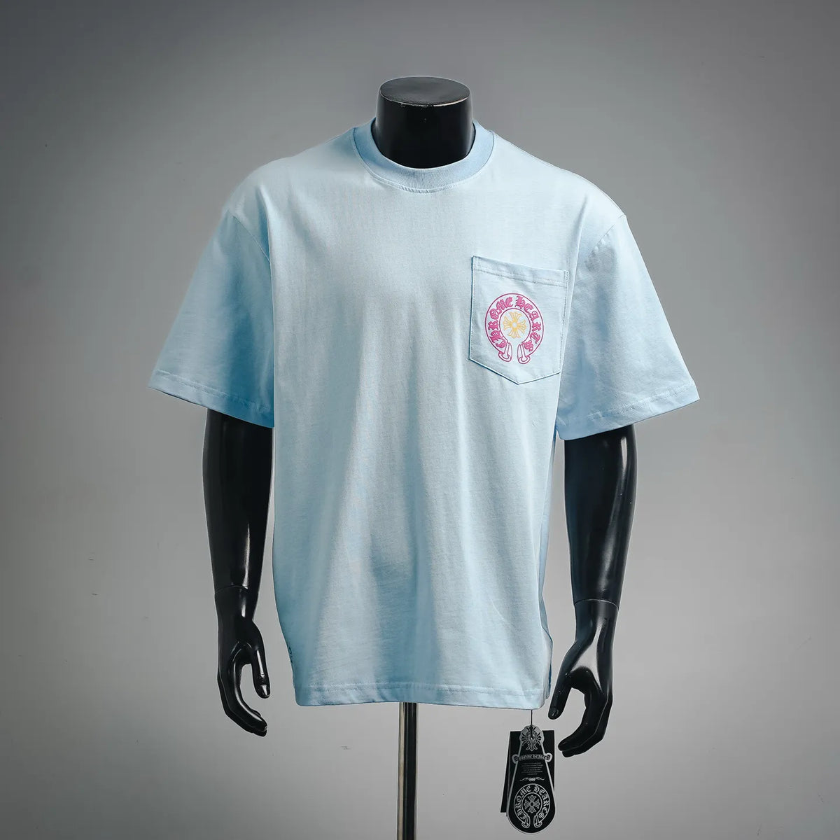 Light blue short-sleeve T-shirt with chest pocket and small circular logo