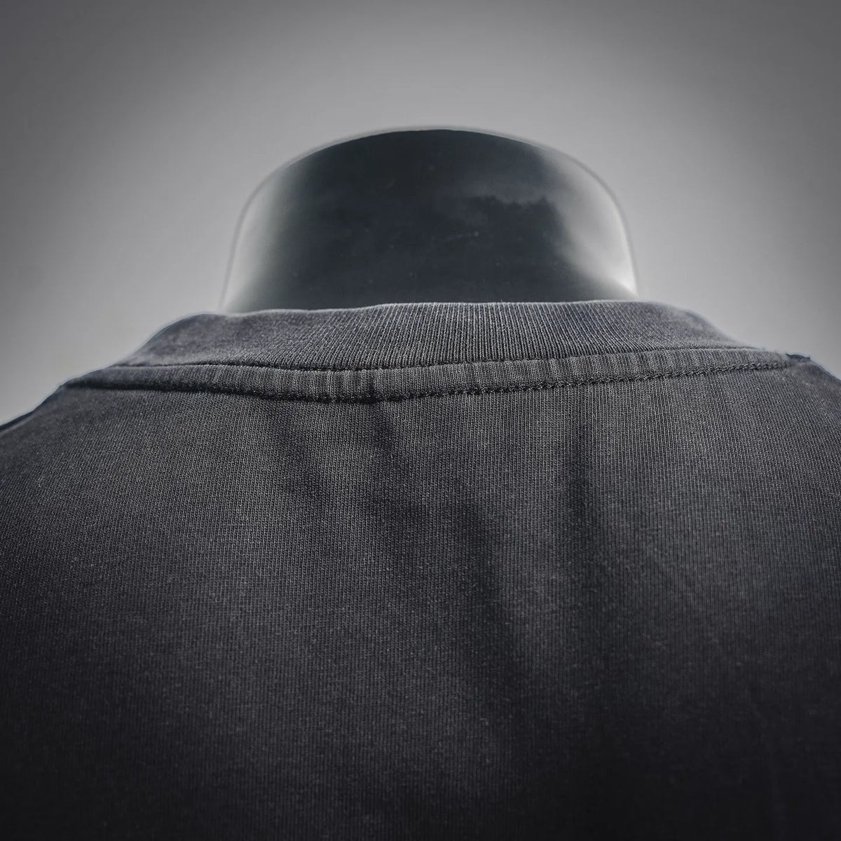 Black crewneck T-shirt neckline with ribbed collar and stitched back yoke seam