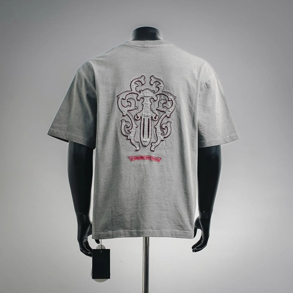 Gray short-sleeve T-shirt with large crest graphic and red underline on back.
