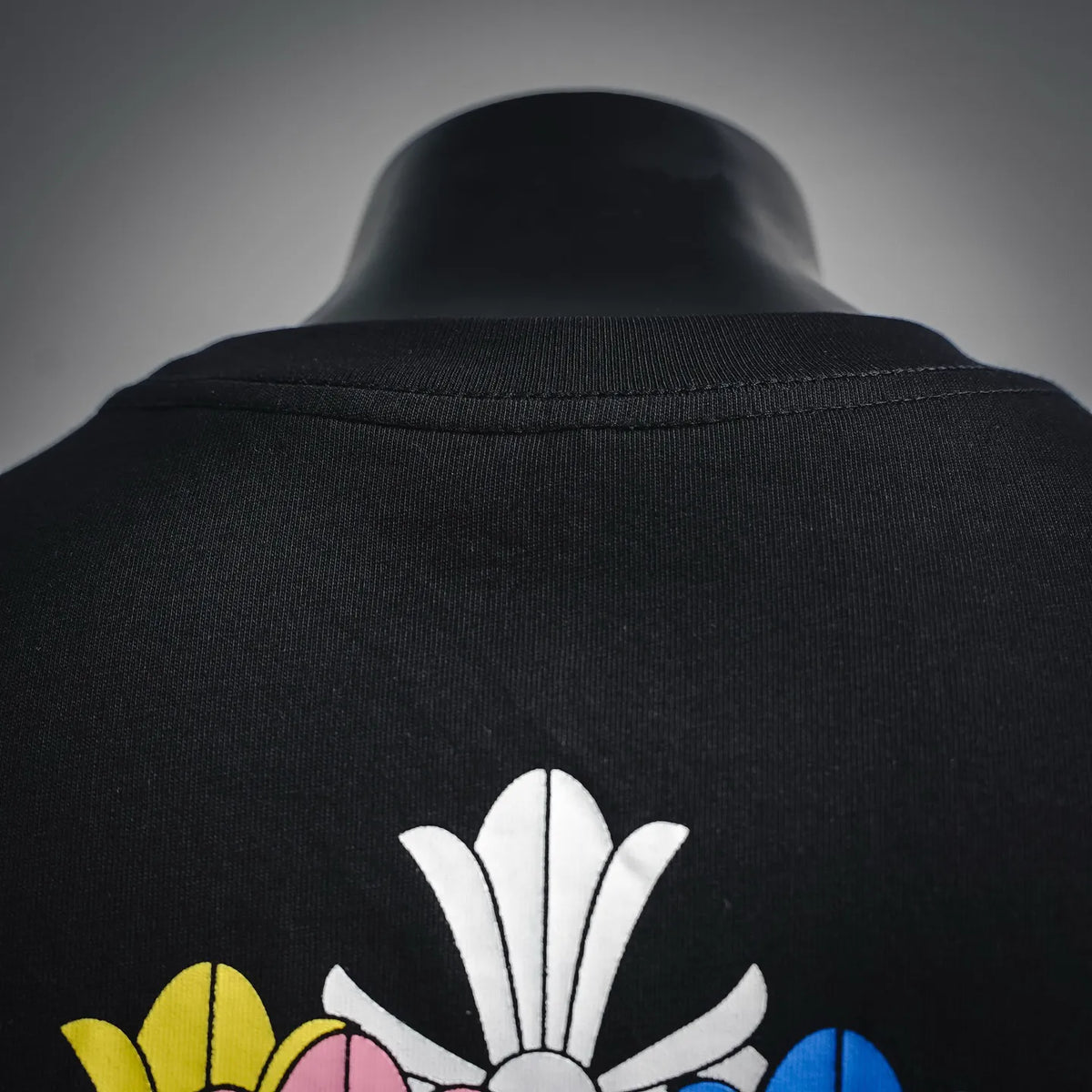 Black short-sleeve T-shirt collar detail with top of flower graphic