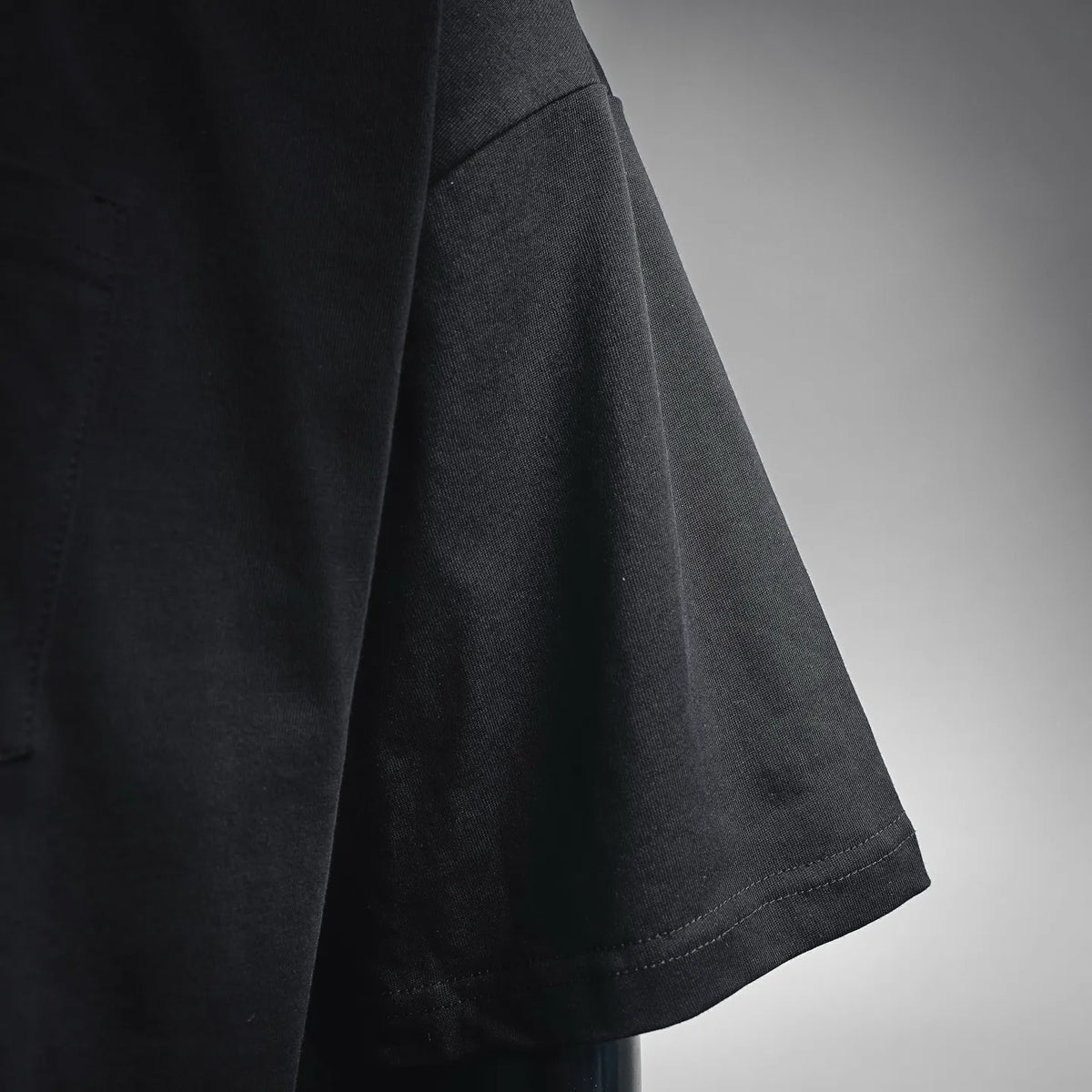 Black short-sleeve T-shirt sleeve and side seam view