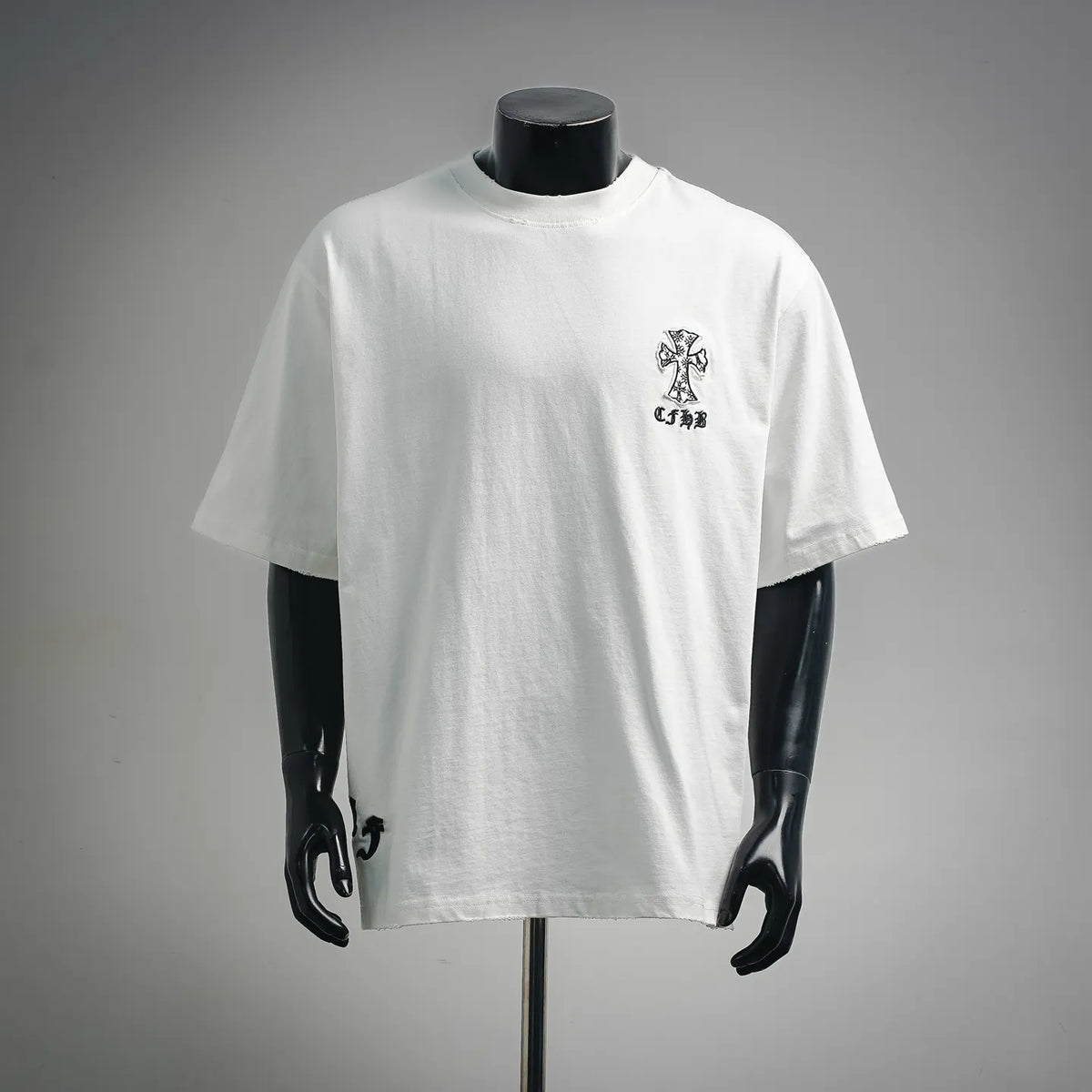 White short-sleeve T-shirt with small black cross graphic on chest.