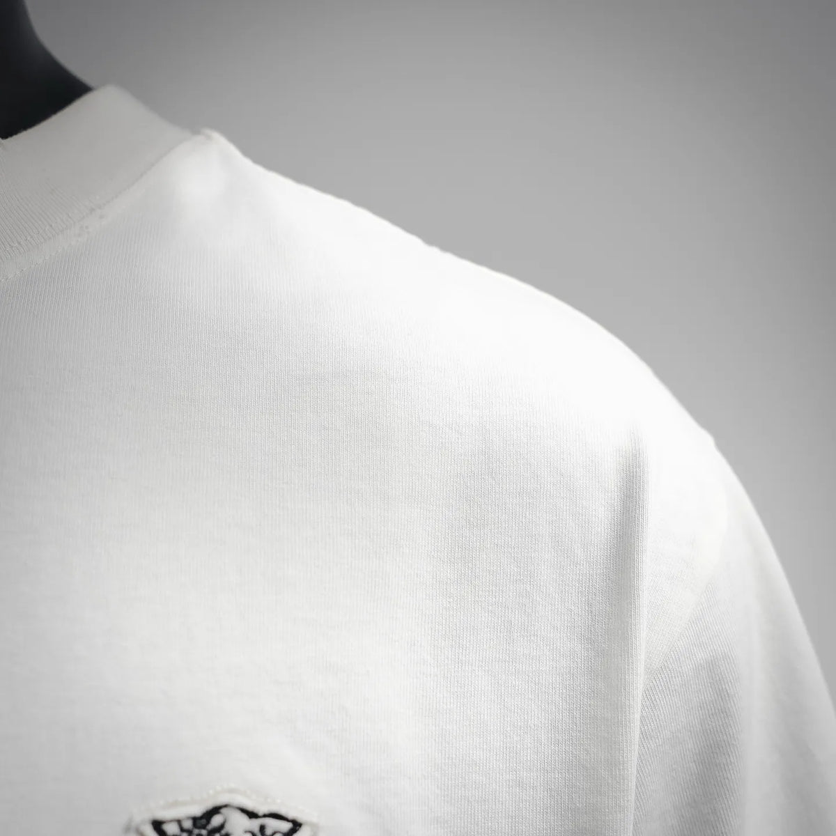 White short-sleeve T-shirt shoulder and sleeve seam close-up.