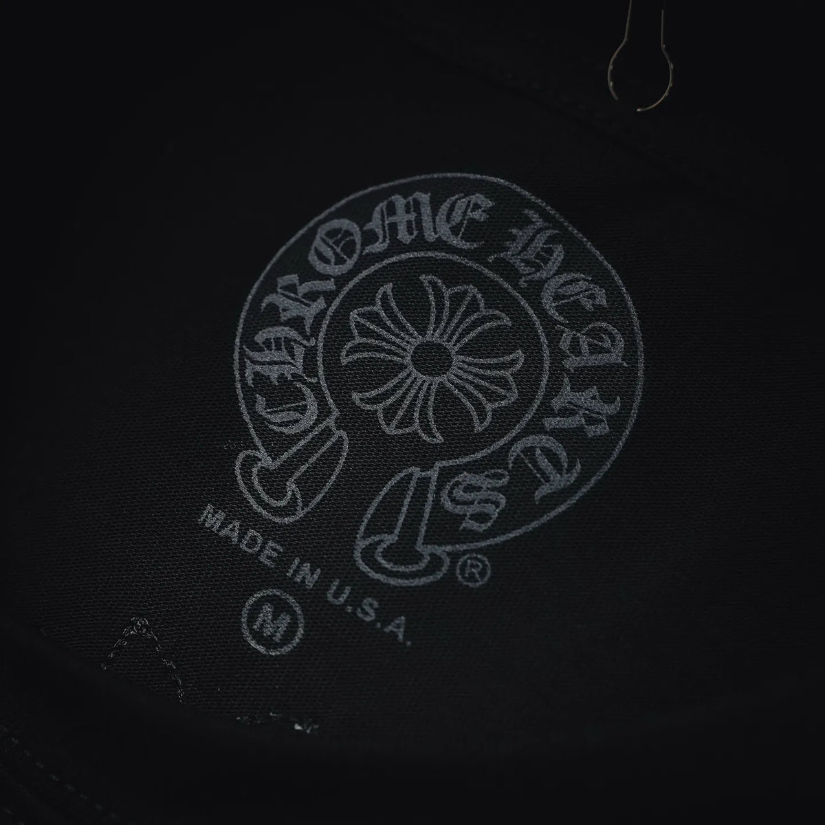 Circular embroidered logo with "MADE IN U.S.A." on the chest of a black tee