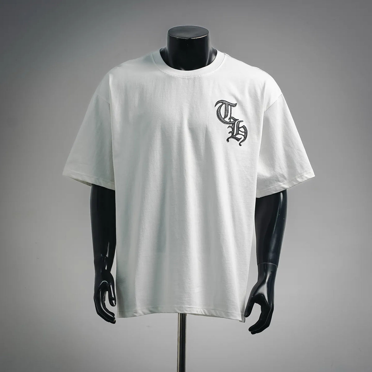 White crewneck T-shirt with small black graphic on left chest