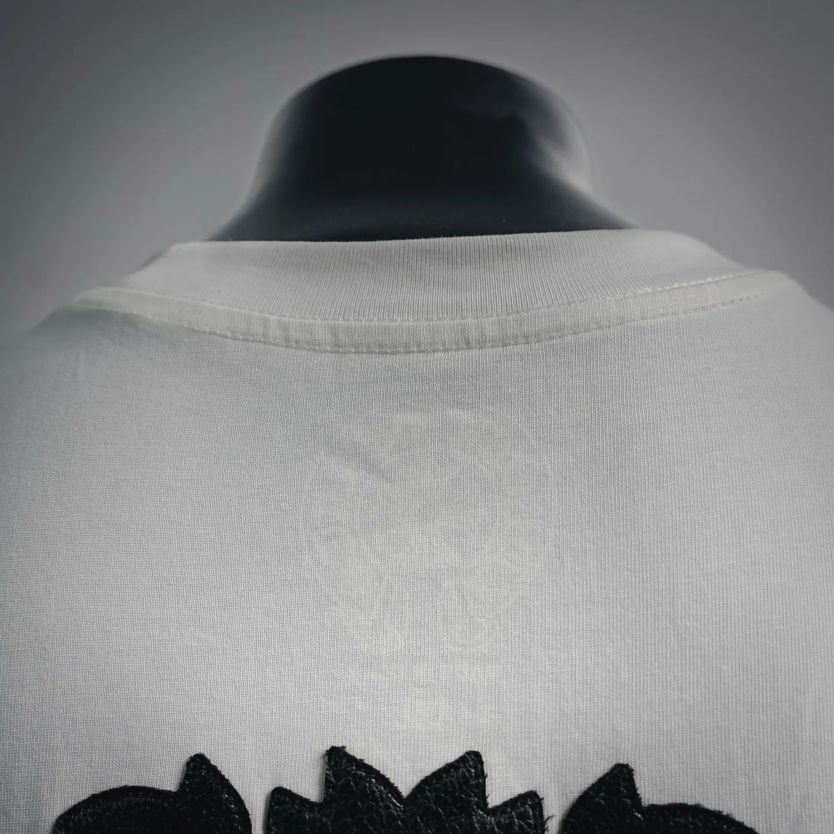 White T-shirt back neckline and collar with partial black graphic below