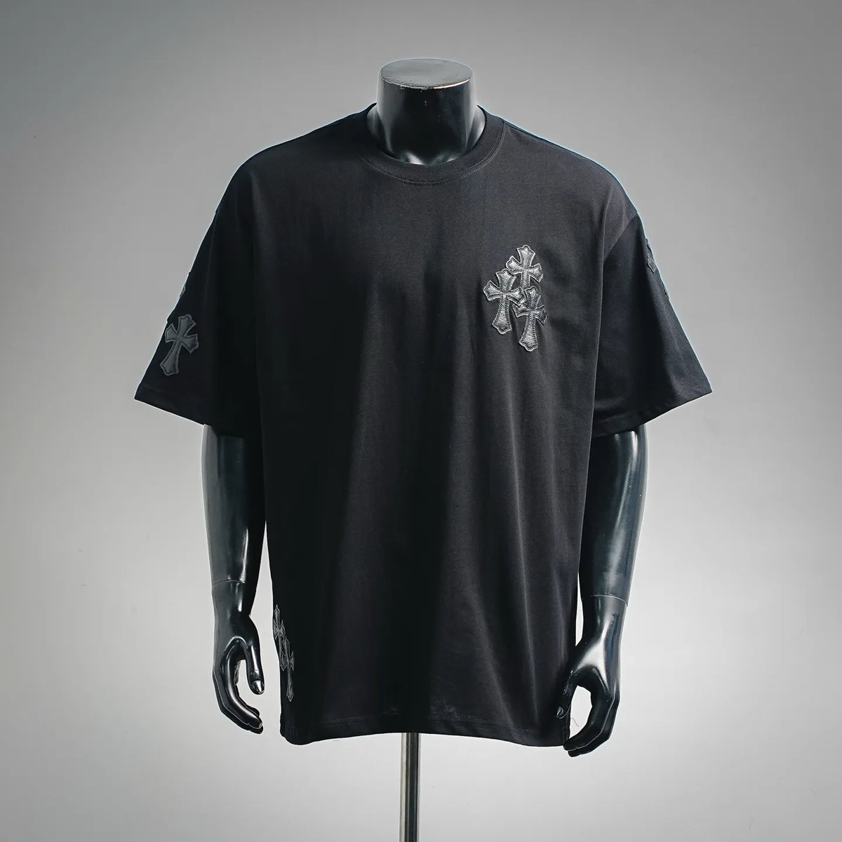 Black short-sleeve crewneck T-shirt with small cross graphic on the chest