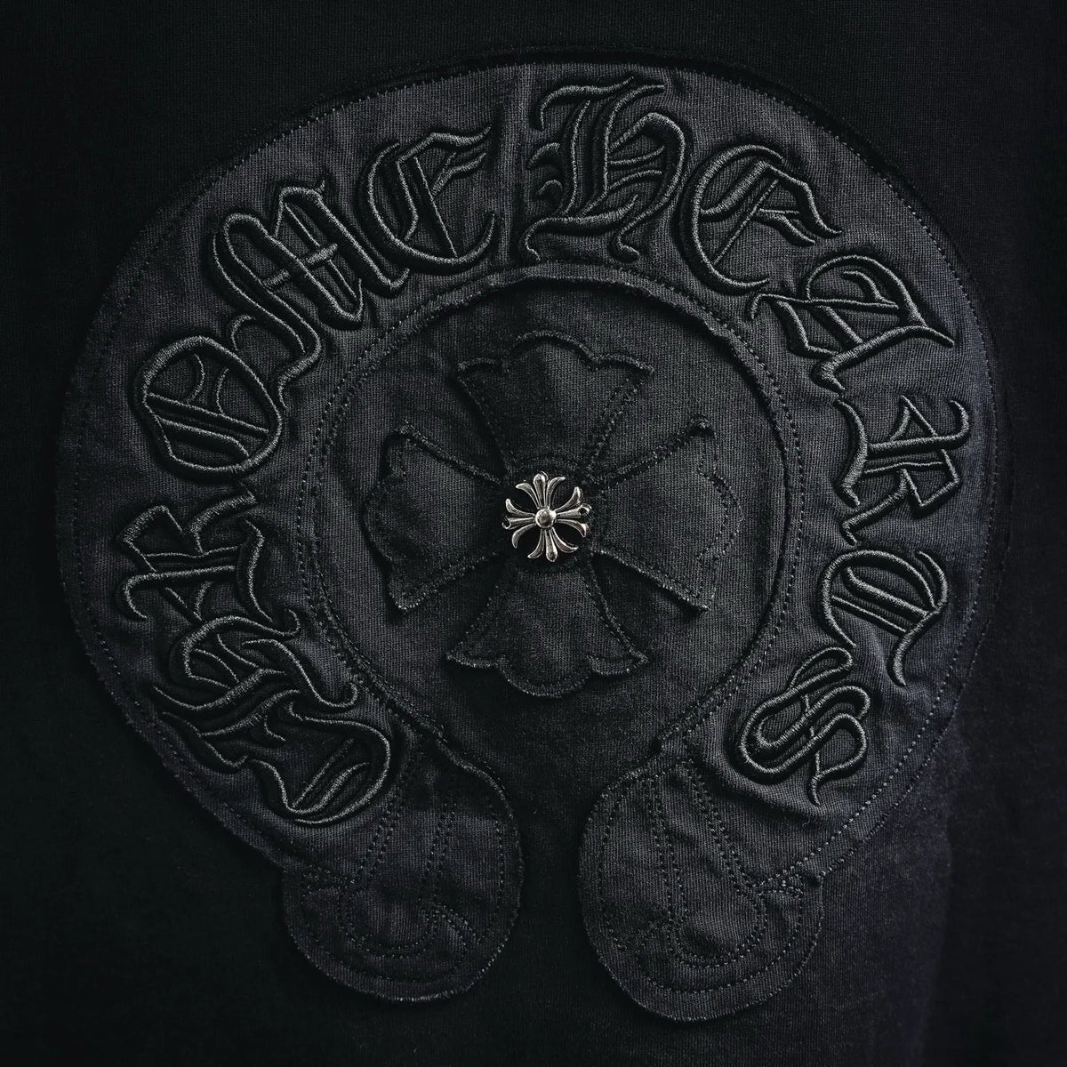 Black T-shirt back logo embroidery detail with flower emblem center